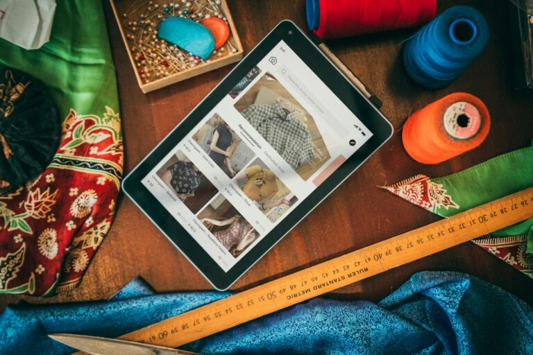 Flat lay of a tablet with sewing supplies, showcasing a digital platform for fabric and patterns.